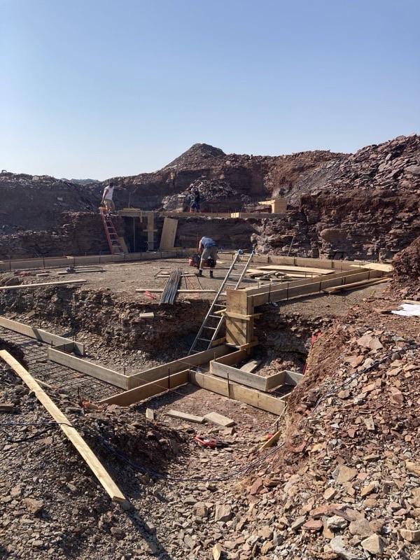 Foundation formwork and rebar on a hillside excavation site
